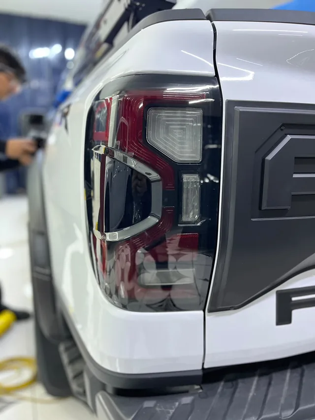 Detalle del conjunto de luces posteriores de una camioneta blanca