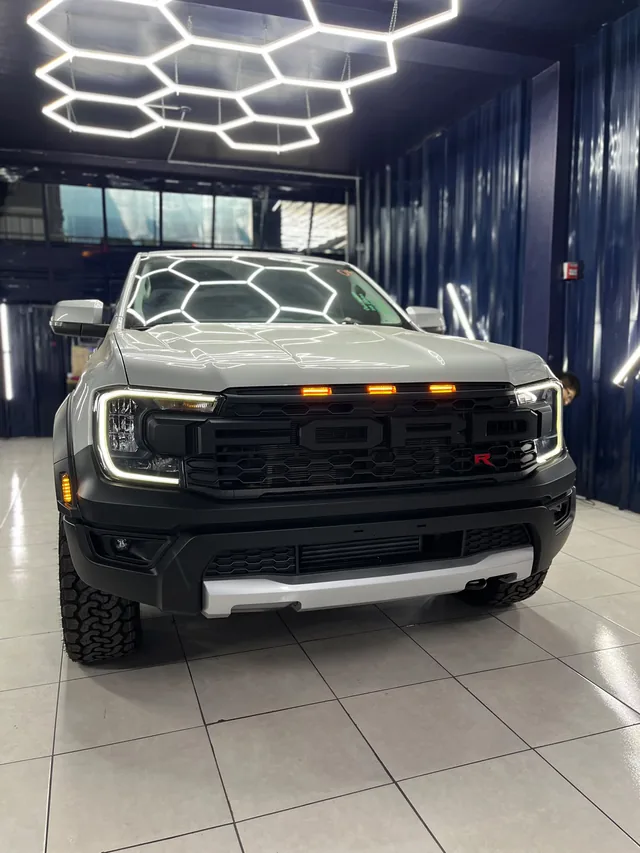 Camioneta Ford blanca bajo las luces LED hexagonales del taller BARMARE