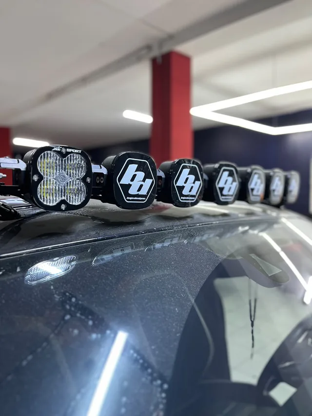 Fila de luces auxiliares sobre el techo de una camioneta, con cubiertas negras