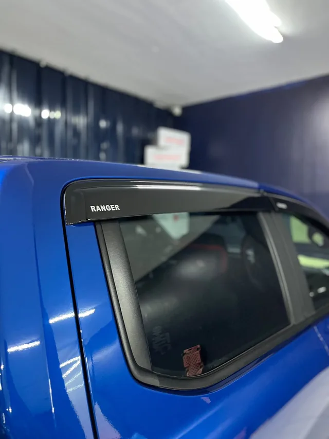 Visera negra identificada Ranger sobre la ventana de una camioneta azul